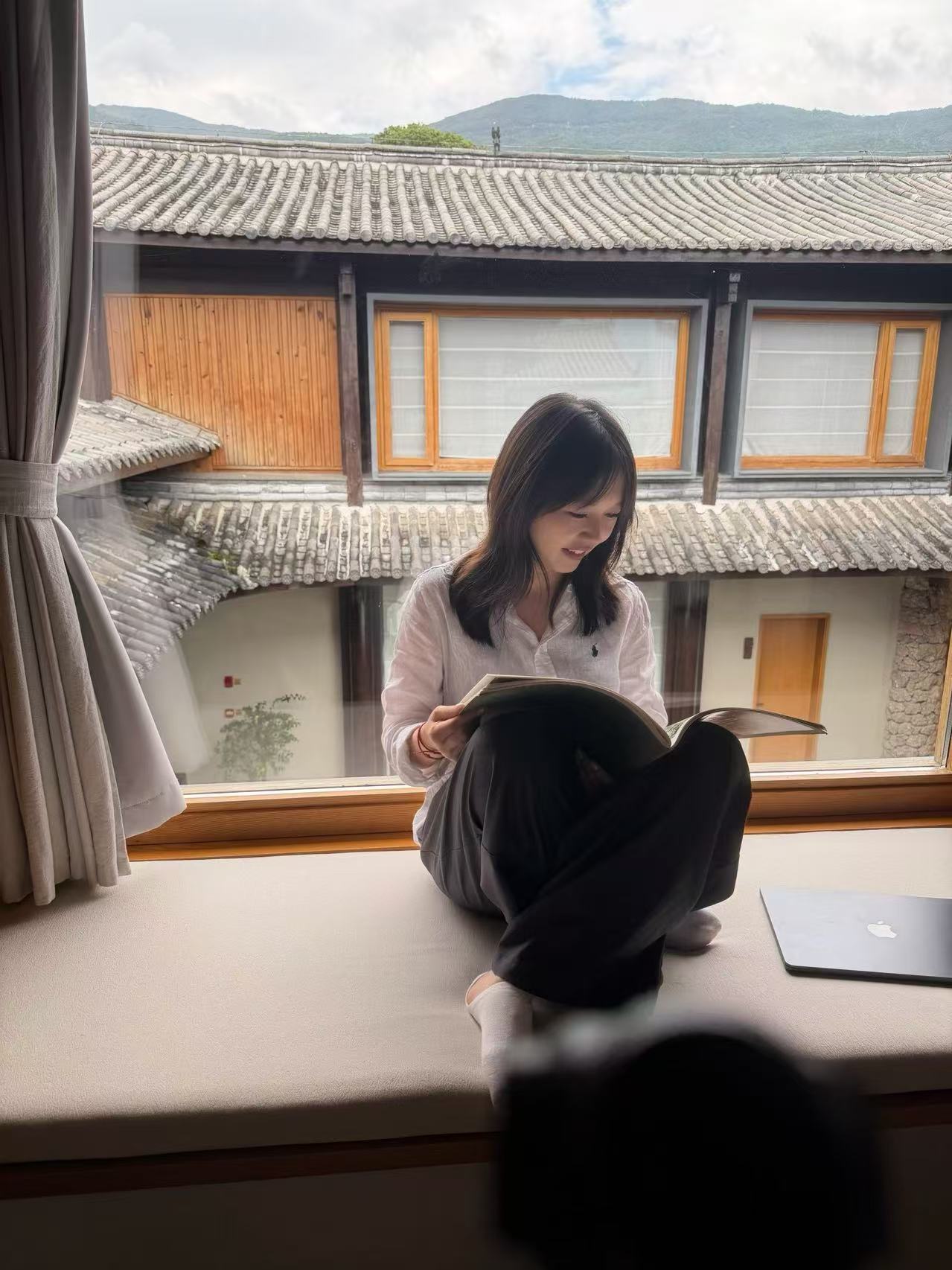 旅行者在传统院落窗边安静阅读